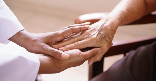 daughter holding elderly mother hand after discussing her SSDI claim