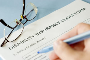 signing insurance claim form on blue background